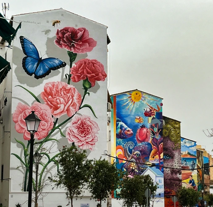 Buildings adorned with colorful floral and animal murals.